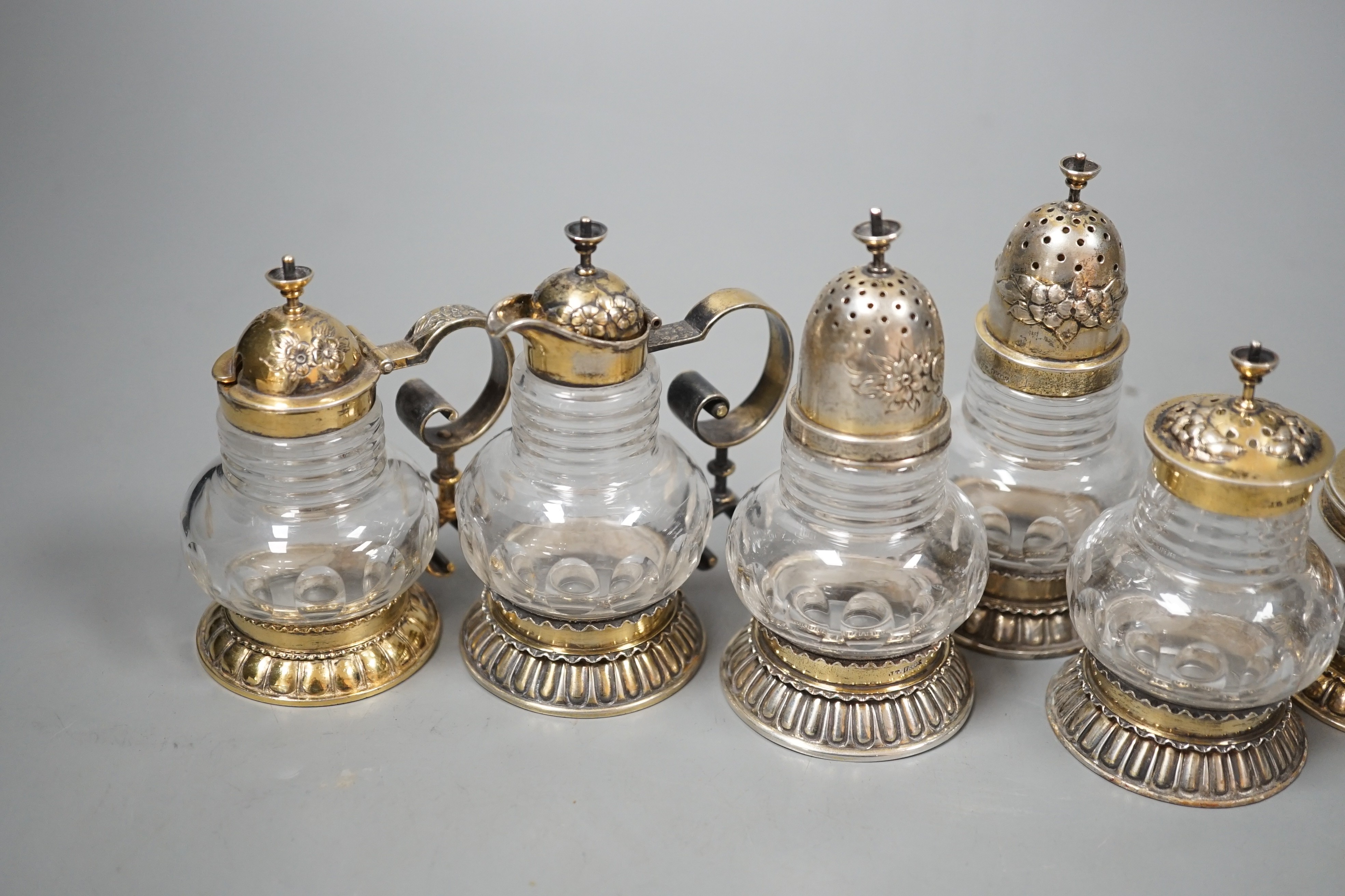 A late 19th/early 20th century Norwegian 830 standard gilt white metal mounted glass six piece cruet set, possibly by J. Tostrup, two pieces unmarked, tallest 97mm.